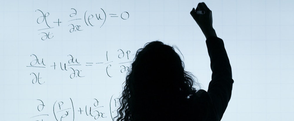 A scientist writing on a whiteboard